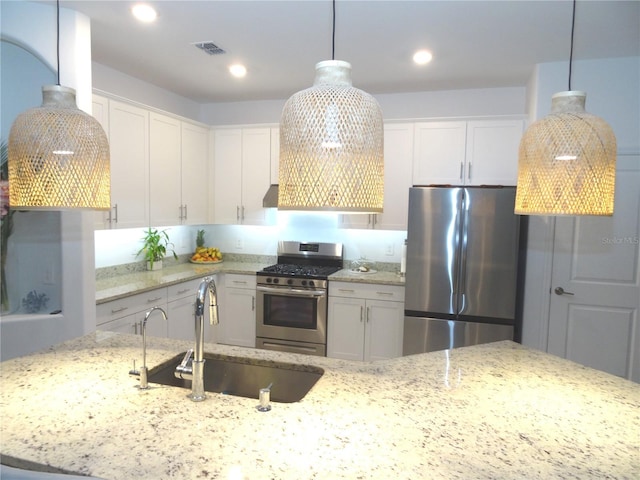 4957 Seafoam Trl, Bradenton, FL 34211 - kitchen with appliances with stainless steel finishes, white cabinetry, hanging light fixtures, light stone counters, and recessed lighting