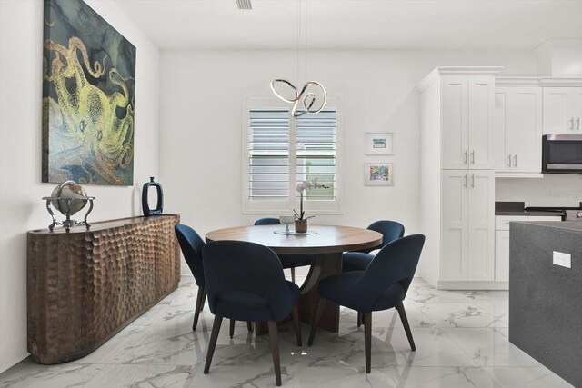 5006 W Idaho St, Tampa, FL 33616 - dining room featuring light marble finish flooring and a chandelier