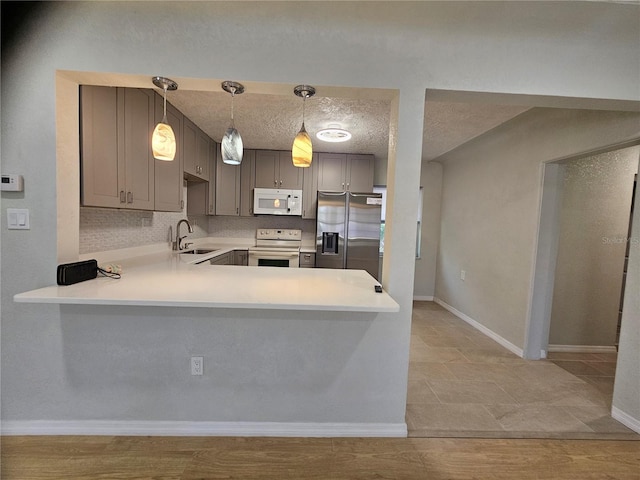 7001 60th St N, Pinellas Park, FL 33781 - kitchen with white appliances, a peninsula, light countertops, gray cabinets, and a textured ceiling