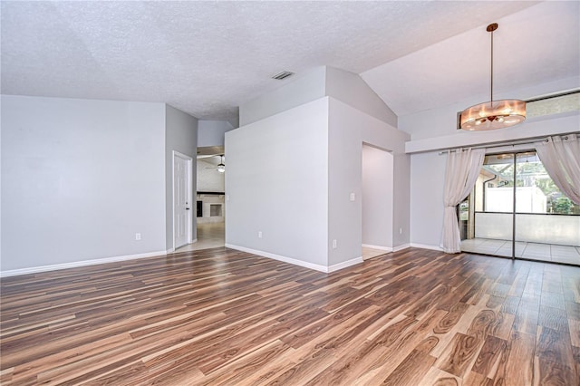 512 Pinewalk Dr, Brandon, FL 33510 - spare room with wood finished floors, a textured ceiling, vaulted ceiling, and a chandelier