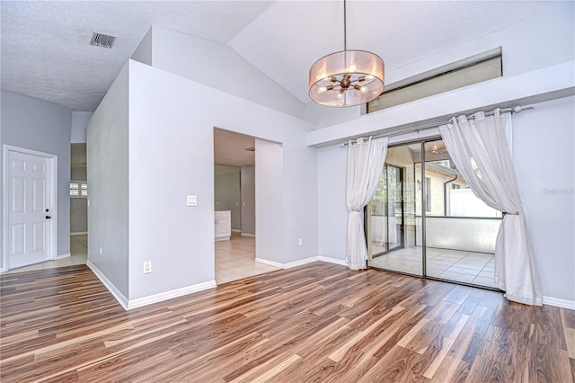 512 Pinewalk Dr, Brandon, FL 33510 - unfurnished room with a chandelier, wood finished floors, and vaulted ceiling