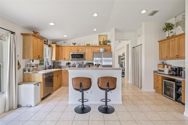 11830 Autumn Creek Dr, Riverview, FL 33569 - kitchen with appliances with stainless steel finishes, wine cooler, a kitchen island, light countertops, and a breakfast bar area