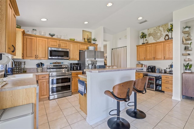 11830 Autumn Creek Dr, Riverview, FL 33569 - kitchen with appliances with stainless steel finishes, a kitchen island, light countertops, light tile patterned floors, and recessed lighting