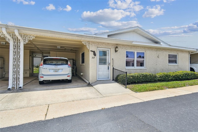 12400 Park Blvd Unit 519, Seminole, FL 33772 - view of front of house featuring concrete driveway, a carport, and brick siding