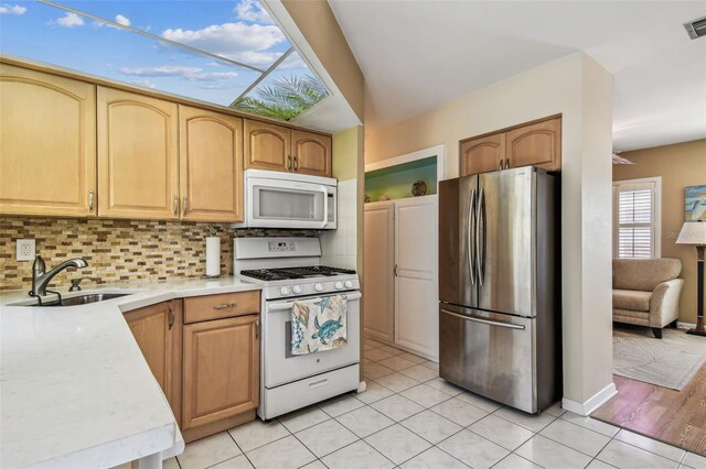 12400 Park Blvd Unit 519, Seminole, FL 33772 - kitchen with white appliances, light countertops, tasteful backsplash, and light tile patterned floors