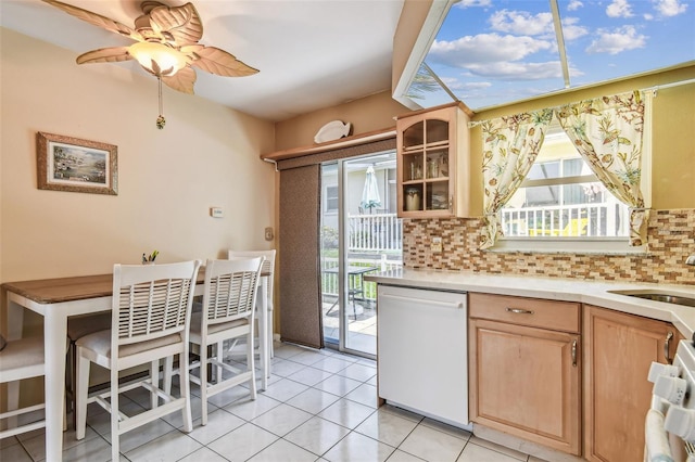 12400 Park Blvd Unit 519, Seminole, FL 33772 - kitchen with white dishwasher, light brown cabinetry, tasteful backsplash, and healthy amount of natural light
