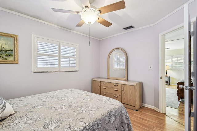 12400 Park Blvd Unit 519, Seminole, FL 33772 - bedroom with light wood-type flooring, multiple windows, ornamental molding, and ceiling fan