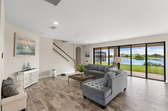 12821 Satin Lily Dr, Riverview, FL 33579 - living area with arched walkways, stairs, wood finished floors, recessed lighting, and a water view