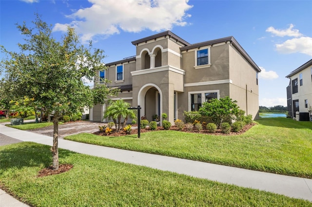 12821 Satin Lily Dr, Riverview, FL 33579 - mediterranean / spanish house featuring stucco siding, a front lawn, a garage, and driveway