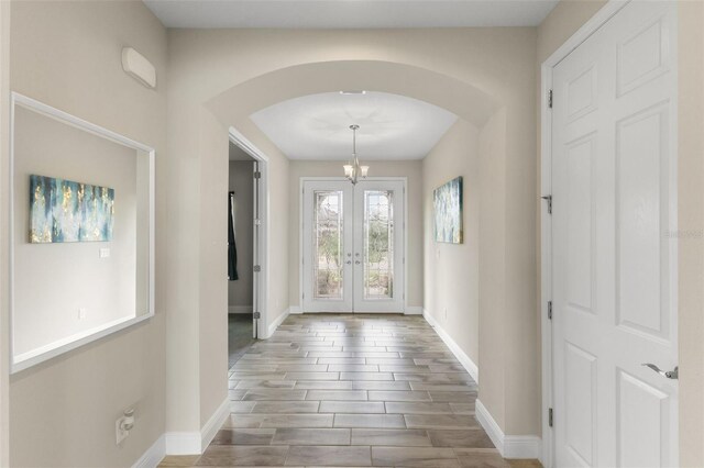 12821 Satin Lily Dr, Riverview, FL 33579 - foyer with arched walkways, wood finished floors, french doors, and a chandelier