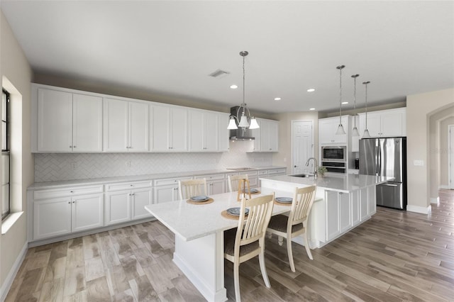 12821 Satin Lily Dr, Riverview, FL 33579 - kitchen featuring appliances with stainless steel finishes, backsplash, light wood finished floors, and recessed lighting