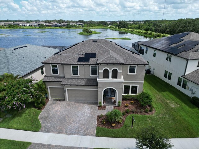 12821 Satin Lily Dr, Riverview, FL 33579 - view of front facade with stucco siding, a water view, a garage, decorative driveway, and a front yard