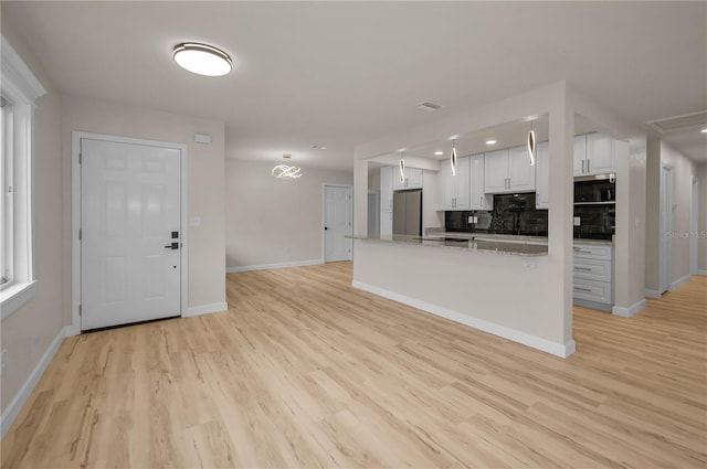 4441 16th St N, Saint Petersburg, FL 33703 - kitchen with stainless steel appliances, white cabinets, tasteful backsplash, light wood finished floors, and recessed lighting
