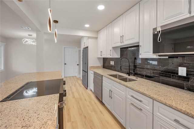 4441 16th St N, Saint Petersburg, FL 33703 - kitchen featuring appliances with stainless steel finishes, light wood-type flooring, tasteful backsplash, recessed lighting, and white cabinets