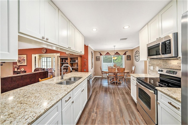 6709 Peachtree Dr, Temple Terrace, FL 33617 - kitchen with stainless steel appliances, dark wood-type flooring, white cabinetry, ornamental molding, and recessed lighting