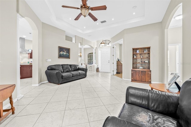 15420 27th Ct E, Parrish, FL 34219 - living room featuring arched walkways, a tray ceiling, a ceiling fan, light tile patterned floors, and recessed lighting