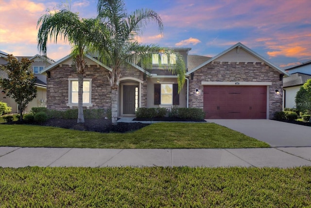2120 Gwynhurst Blvd, Wesley Chapel, FL 33543 - view of front of home with stone siding, an attached garage, driveway, and a front yard