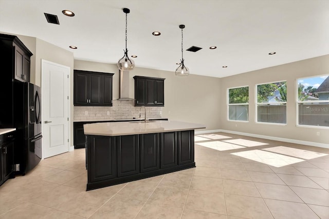 2120 Gwynhurst Blvd, Wesley Chapel, FL 33543 - kitchen featuring freestanding refrigerator, dark cabinets, wall chimney range hood, light tile patterned floors, and recessed lighting