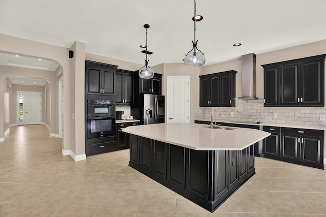 2120 Gwynhurst Blvd, Wesley Chapel, FL 33543 - kitchen featuring wall chimney exhaust hood, dark cabinets, black appliances, arched walkways, and recessed lighting