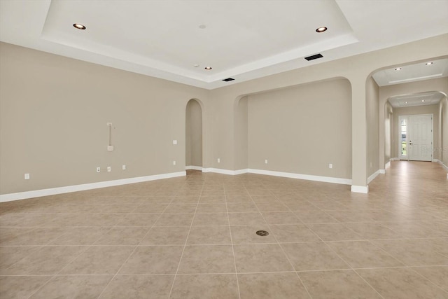 2120 Gwynhurst Blvd, Wesley Chapel, FL 33543 - spare room featuring a raised ceiling, arched walkways, recessed lighting, and light tile patterned floors