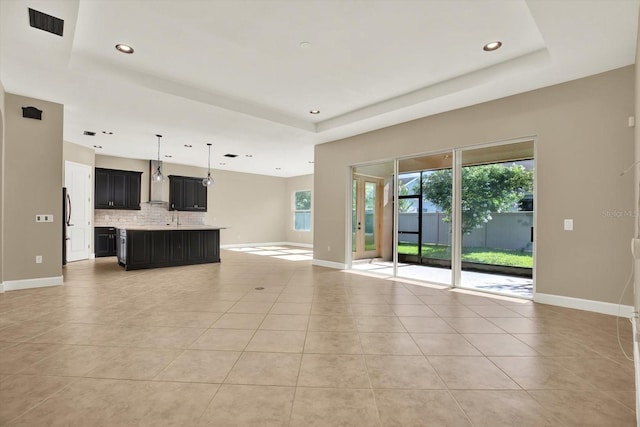 2120 Gwynhurst Blvd, Wesley Chapel, FL 33543 - unfurnished living room featuring a raised ceiling, light tile patterned floors, and recessed lighting