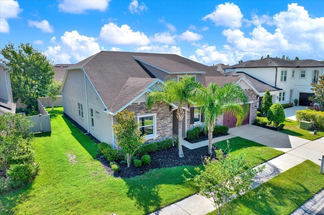 2120 Gwynhurst Blvd, Wesley Chapel, FL 33543 - view of front of house featuring stone siding, concrete driveway, a residential view, roof with shingles, and an attached garage