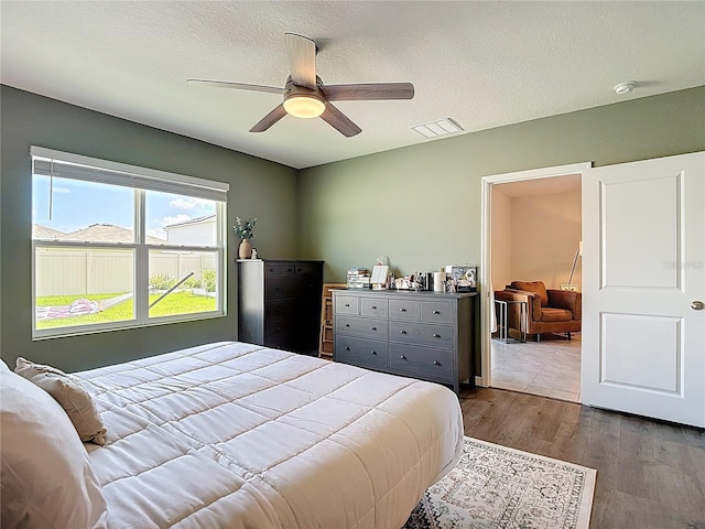 34033 Jasper Stone Dr, Wesley Chapel, FL 33543 - bedroom with wood finished floors, a textured ceiling, and a ceiling fan