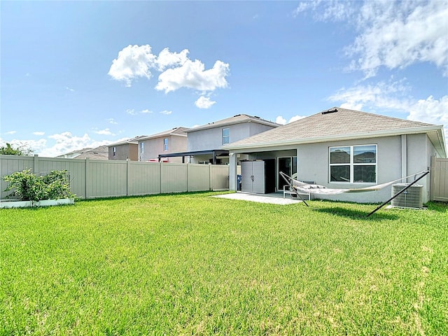 34033 Jasper Stone Dr, Wesley Chapel, FL 33543 - rear view of property featuring a fenced backyard, a patio, stucco siding, and roof with shingles