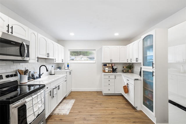 5055 9th St, Zephyrhills, FL 33542 - kitchen featuring stainless steel appliances, decorative backsplash, light wood-style floors, light countertops, and recessed lighting