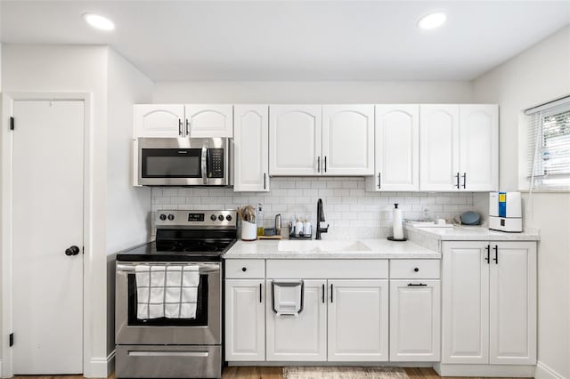 5055 9th St, Zephyrhills, FL 33542 - kitchen featuring stainless steel appliances, white cabinetry, decorative backsplash, and recessed lighting
