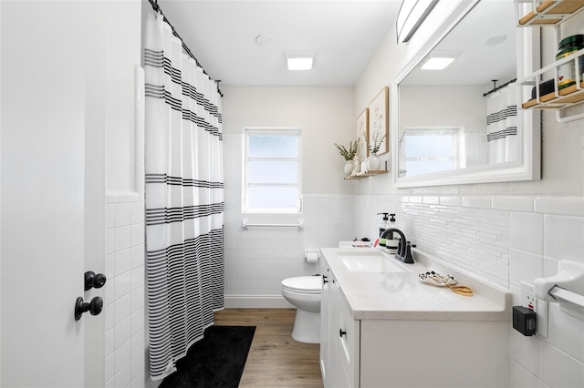 5055 9th St, Zephyrhills, FL 33542 - full bath featuring tile walls, vanity, wood finished floors, a wainscoted wall, and a shower with curtain