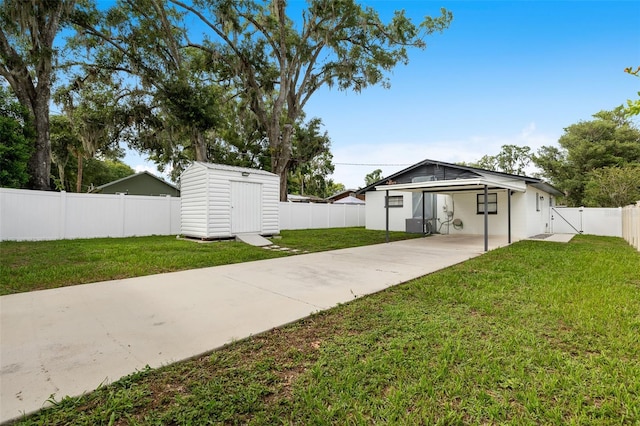 5055 9th St, Zephyrhills, FL 33542 - fenced backyard featuring concrete driveway, a storage unit, an attached carport, and a gate