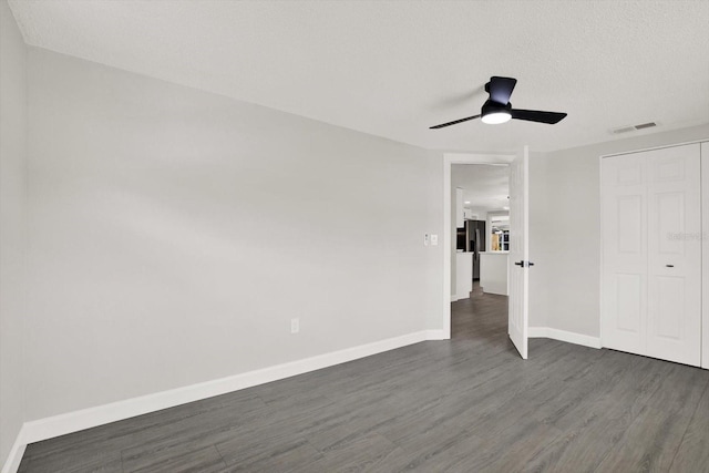 7835 Wallaba Ln, New Port Richey, FL 34653 - unfurnished bedroom featuring dark wood-type flooring, stainless steel fridge with ice dispenser, a closet, and ceiling fan