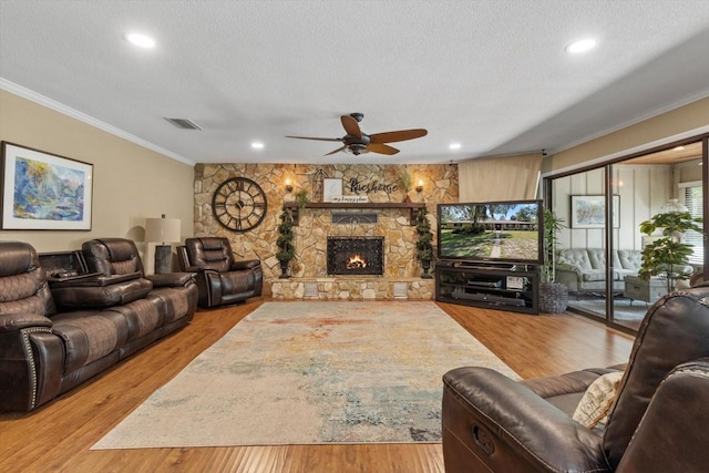 10584 N Dawnflower Pt, Crystal River, FL 34428 - living room with ornamental molding, ceiling fan, a textured ceiling, a fireplace, and wood finished floors
