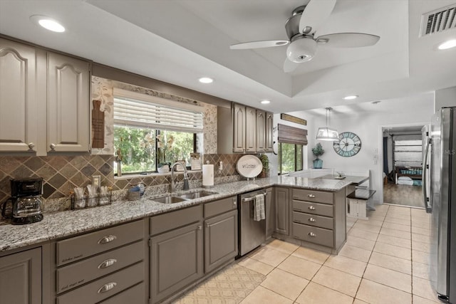 10584 N Dawnflower Pt, Crystal River, FL 34428 - kitchen with stainless steel appliances, a peninsula, a raised ceiling, a ceiling fan, and tasteful backsplash