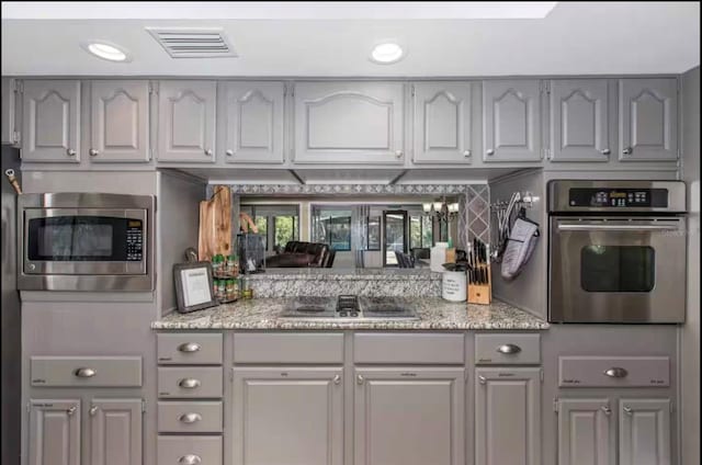 10584 N Dawnflower Pt, Crystal River, FL 34428 - kitchen with stainless steel appliances, gray cabinetry, and light stone counters