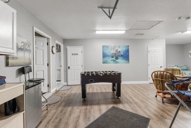 10584 N Dawnflower Pt, Crystal River, FL 34428 - playroom with light wood finished floors, attic access, and a textured ceiling