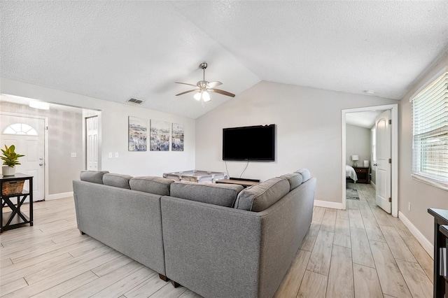 602 Timber Bay Cir W, Oldsmar, FL 34677 - living room with light wood-style floors, a ceiling fan, vaulted ceiling, and a textured ceiling