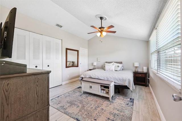 602 Timber Bay Cir W, Oldsmar, FL 34677 - bedroom with vaulted ceiling, light wood-style floors, a textured ceiling, a closet, and a ceiling fan
