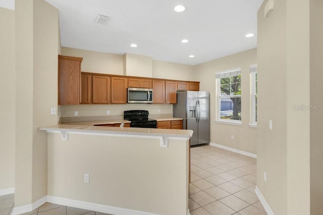 12975 Calderdale Ave, Windermere, FL 34786 - kitchen with appliances with stainless steel finishes, light countertops, a kitchen bar, a peninsula, and light tile patterned flooring