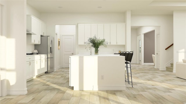 6830 E 115th St, Palmetto, FL 34221 - kitchen featuring an island with sink, stainless steel refrigerator with ice dispenser, light wood-style floors, and white cabinets