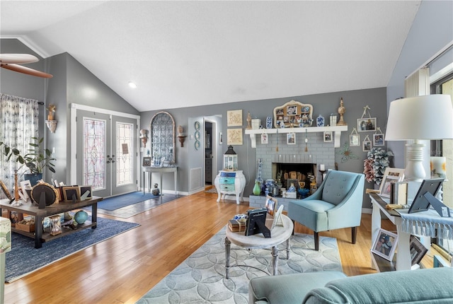 12234 Cider Mill Ln, Hudson, FL 34667 - living area featuring vaulted ceiling, french doors, wood finished floors, and a brick fireplace