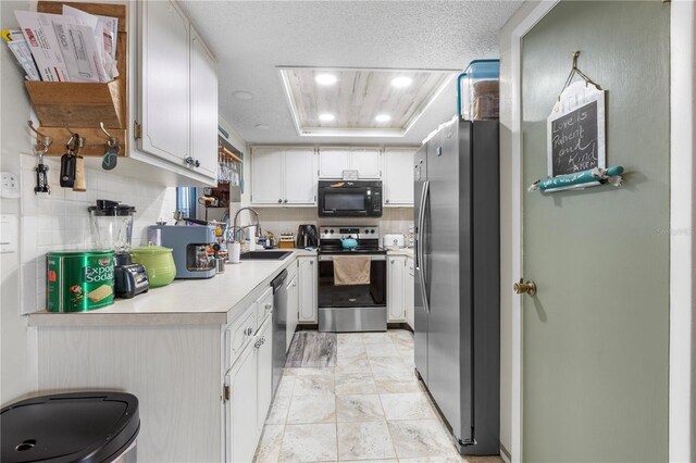 12234 Cider Mill Ln, Hudson, FL 34667 - kitchen featuring appliances with stainless steel finishes, light countertops, a tray ceiling, white cabinets, and recessed lighting