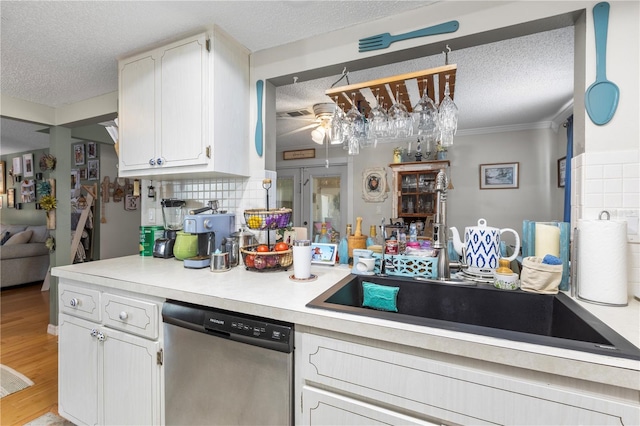 12234 Cider Mill Ln, Hudson, FL 34667 - kitchen featuring stainless steel dishwasher, a textured ceiling, white cabinets, tasteful backsplash, and light countertops