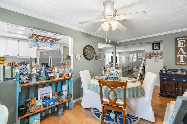 12234 Cider Mill Ln, Hudson, FL 34667 - dining area featuring light wood-style floors, a textured ceiling, ceiling fan, and ornamental molding