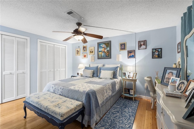 12234 Cider Mill Ln, Hudson, FL 34667 - bedroom featuring multiple closets, wood finished floors, a textured ceiling, and ceiling fan