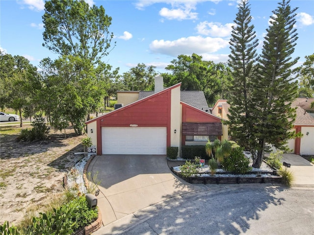 12234 Cider Mill Ln, Hudson, FL 34667 - view of front of property with concrete driveway, an attached garage, stucco siding, and a chimney