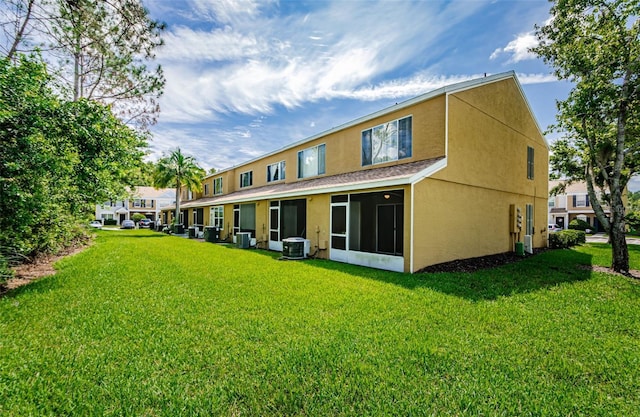 1241 Redondo Way, Wesley Chapel, FL 33543 - back of property with stucco siding, a lawn, and a sunroom
