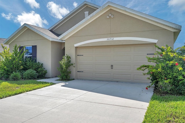 30732 Summer Sun Loop, Wesley Chapel, FL 33545 - view of front of property with driveway, an attached garage, and stucco siding