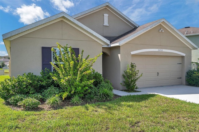 30732 Summer Sun Loop, Wesley Chapel, FL 33545 - view of front of house with concrete driveway, an attached garage, stucco siding, and a front lawn